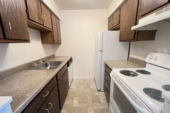 An empty kitchen with a stove sink and refrigerator